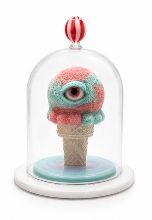 One-eyed pink-and-aqua felt ice cream scoop on a waffle cone beneath a clear glass dome topped with a red-and-white striped knob.
