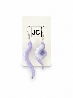Asymmetrical lavender glass tentacle earrings with white suckers, one long and one curled, on silver hooks displayed on a white JC2 card.