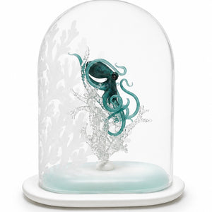 Shelter Within glass sculpture featuring a teal octopus among white coral forms inside a clear dome with sand-carved coral imagery on a white base.

