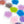 Cast glass water lilies with layered translucent petals in pink, purple, blue, coral, orange, gray, and lime green, arranged on a white background.
