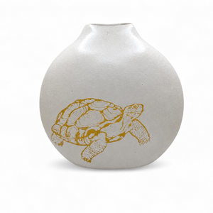 Tortoise Vase in frosted white blown glass with a rounded body, narrow opening, and a golden-yellow tortoise design on the front.