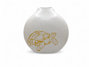 Tortoise Vase in frosted white blown glass with a rounded body, narrow opening, and a golden-yellow tortoise design on the front.